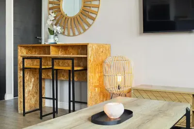 a living room with a table and a mirror at Cape on Porterfield 5 in Bloubergstrand
