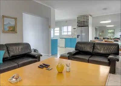 a living room with two leather couches and a wooden table at Island Time in Hermanus