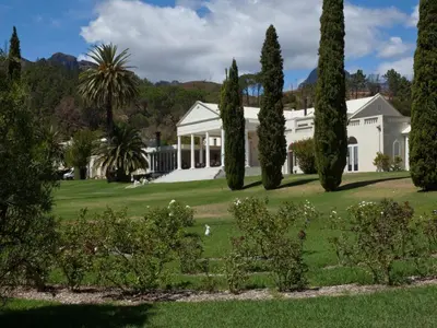 a large white house with trees in front of it at Retreat at Waterfall Valley in Paarl