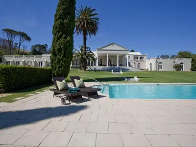 a villa with a swimming pool and a house at Retreat at Waterfall Valley in Paarl