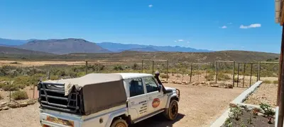 a white truck parked in the middle of the desert at Phumelela Private Game Farm in Pinegrove
