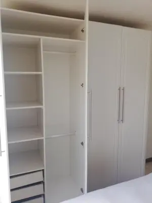 a closet with white cabinets and shelves at Rondebosch East Garlandale STRICTLY HALAAL, fresh garden cottage in Cape Town
