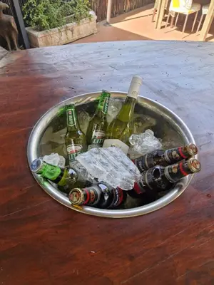 a bucket filled with bottles of wine on a table at Regent Casa’s in Cape Town