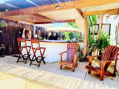 a patio with three chairs and an outdoor bar at Regent Casa’s in Cape Town