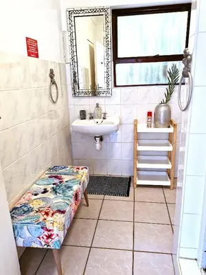 a bathroom with a sink and a bench in it at Regent Casa’s in Cape Town