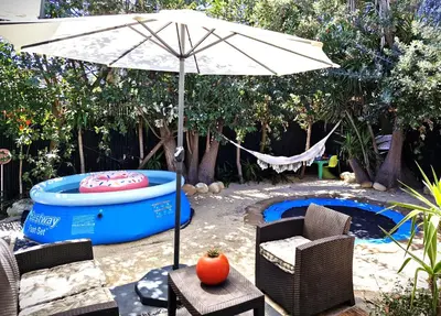 an umbrella and chairs next to a hot tub at Regent Casa’s in Cape Town