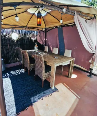 a wooden table and chairs under a tent at Regent Casa’s in Cape Town