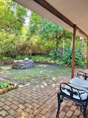 a bench on a brick patio with a garden at 81 Kingfisher in Lake Marina