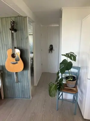 a room with a guitar on the wall and a plant at Great spot with a view in Hermanus , South Africa in Hermanus