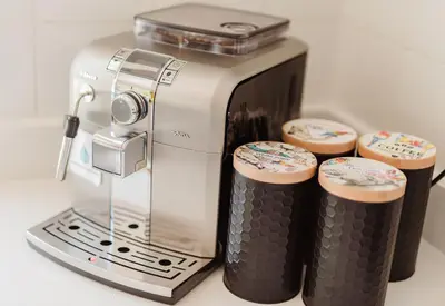 a silver coffee maker with three cups on a counter at Luxury suite near Church Street in Stellenbosch